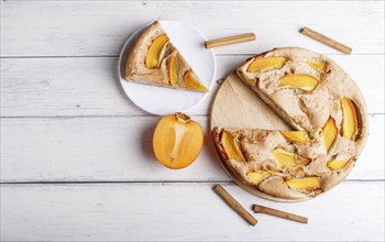 Sweet persimmon pie on white wooden background. top view, copy space