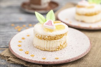 Decorated cake with milk and coconut cream with cup of coffee on a gray wooden background and linen