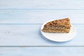 Walnut and hazelnut cake with caramel cream on blue wooden background. side view, copy space