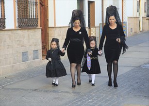 Two women and little girls dressed in black for Easter procession, Setenil de las Bodegas, Cadiz