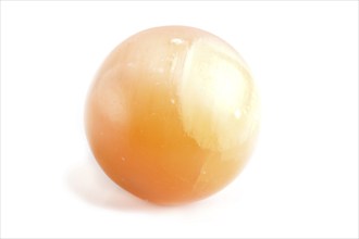 Orange onyx sphere isolated on white background, close up