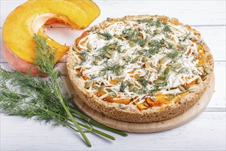 Sweet pumpkin pie with cheese and dill on white wooden background. close up