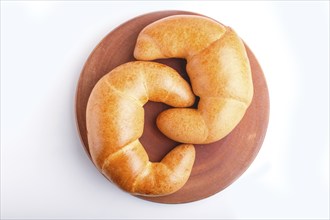 Two croissants on a wooden cutting board isolated on white background. closeup. top view