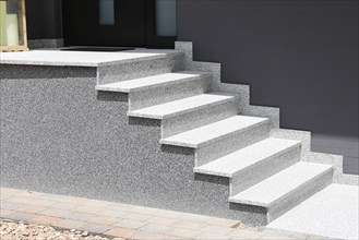 Block stepped staircase with plinth made of coloured stone plaster as an entrance staircase to a