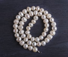 White pearl beads on a black background. top view, close up