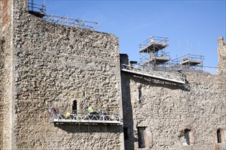 Stonemasons doing maintenance repairs to the stone walls of Framlingham castle, Suffolk, England,