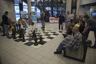 Men playing chess with a giant set of board and pieces in the central library, Rotterdam,