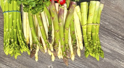 Green asparagus and white asparagus decorated on a rustic wooden table