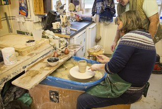 Woman pottery class lesson learning making pot in potters studio UK