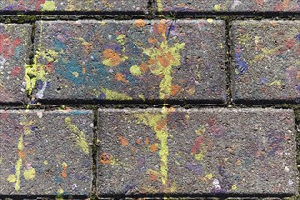 Multicolored spots of paint on a concrete slab