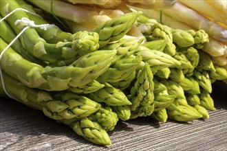 Green asparagus and white asparagus decorated on a rustic wooden table