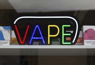 Electric colourful sign for VAPE products in shop window, England, UK