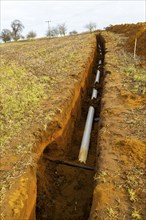 Farm irrigation water supply pipeline excavated in sandy soil, Shottisham, Suffolk, England, UK