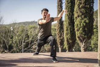 A man immerses himself in the practice of Kung Fu, a Chinese martial art, in the stance within the