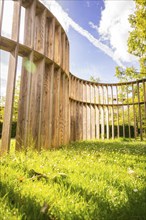 An ornate wooden structure stretches into the sky against an idyllic backdrop, Stadtpark Kleb,