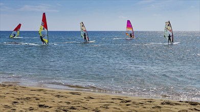 Windsurfer on the sea in sunny weather with colourful sails, surfer's paradise, kitesurfer,