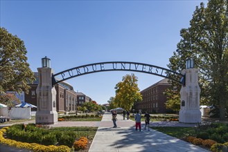 Students under Gateway to the Future arch on the campus of Purdue University in West Lafayette,