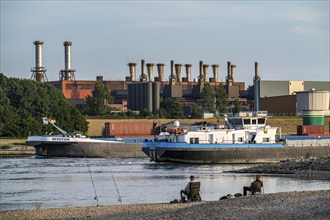 Industrial backdrop of the ThyssenKrupp Steel steelworks in Bruckhausen, on the Rhine, anglers in a