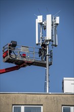 Assembly, installation of a 5G mobile radio transmitter, mast on a residential building, fast