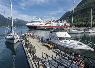 Andalsnes harbour, sailing boats and Hurtigruten ship anchor in the harbor on a sunny summer day.