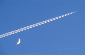 Aeroplane in the sky, vapour trail, crescent moon, waxing crescent moon, over Frankfurt am Main