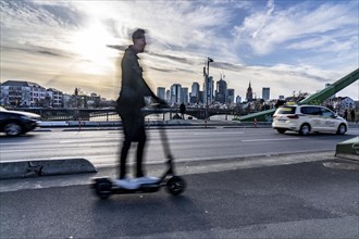 Skyline of Frankfurt am Main, skyscrapers, e-scooter rider on the Flößerbrücke, Hesse, Germany,