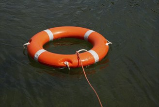 Lifebuoy with lifeline in the water, distress at sea, drowning, accident, danger, shipping,