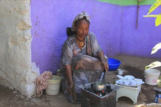 In the highlands of Abyssinia, in the village of Sina, young woman roasting coffee for the coffee