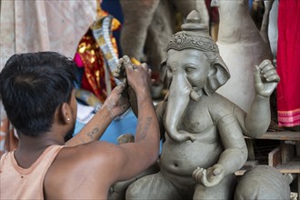 Artisan work on idols of the elephant-headed Hindu deity Ganesha at a workshop ahead of the Ganesh