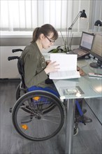 Young woman in a wheelchair at her workplace, Berlin, 18/01/2017