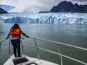 Tourists visiting the San Rafael glacier lagoon, view from excursion boat towards glacier front,