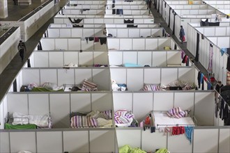 Temporary rooms with beds are set up in an emergency shelter for refugees on 9 December 2015 in a