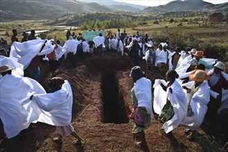 People are participating in a famadihana, a funerary tradition also known as the turning of the