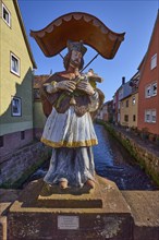 Figure of a saint with Jesus on the cross and canopy on the Stone Bridge in Amorbach, Lower