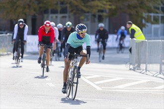 Several cyclists in a road race moving vigorously forward while being cheered on by spectators