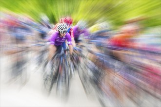 Cyclist in sportswear and helmet riding at high speed on a road, race, the motion blur emphasises