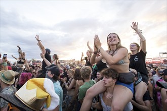 Festival visitors are carried on shoulders during the performance of the band Feine Sahne