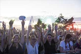 Festival visitors illuminate the site with mobile phone lights at the Highfield Festival on Friday,