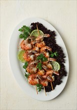 Shrimp kebab, with spices, lime, on wooden skewers, top view, no people