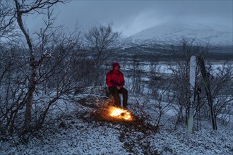 Man at the campfire, Stora Sjöfallet National Park, World Heritage Laponia, Norrbotten, Lapland,