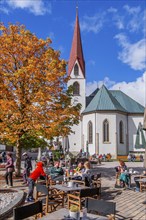 Village square with pilgrimage church of St. Oswald in autumn, Seefeld in Tyrol, Seefeld Plateau,