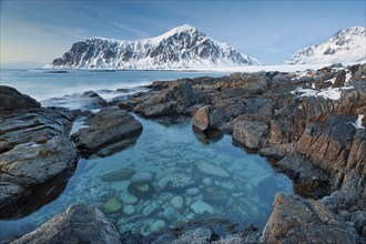 Long exposure, winter at Skagsanden, rocks washed over by the sea on the beach at Flakstad,