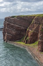 Red coloured sandstone, steep cliff coast of the offshore island of Heligoland, home of the