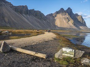 Tourists on path to viking village, rebuild viking houses at Stokksnes, east of Höfn, East Fjords,