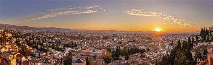 Panoramic view of a cityscape at sunset with bright sky, Granada