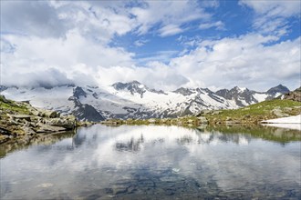 Picturesque mountain landscape with mountain lake, mountains and glaciers reflected in the