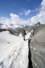 Mountaineer on a hiking trail with snow, ascent to the Nordliche Mörchnerscharte, behind mountain