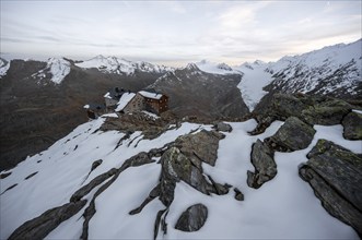 Snow-covered mountain landscape, mountain hut Ramolhaus in autumn with snow, at sunset, view of