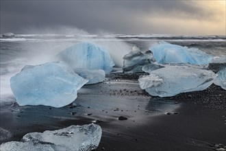 Ice floes on the beach, waves, sea, clouds, sunlight, winter, Diamond Beach, Breidamerkursandur,