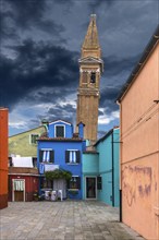 Colourful residential buildings, behind the leaning tower of the church of St. Martin Vescovo, 16th